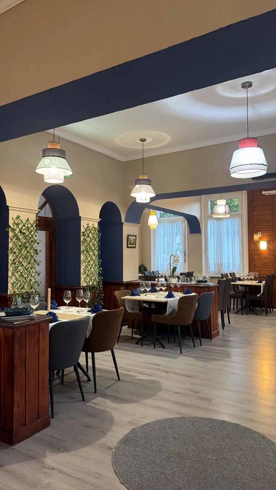 La salle du restaurant, arcades bleu nuit et suspensions en rotin